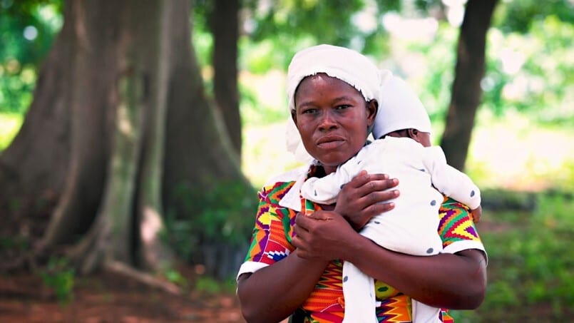 Matilda carrying her baby looking at camera